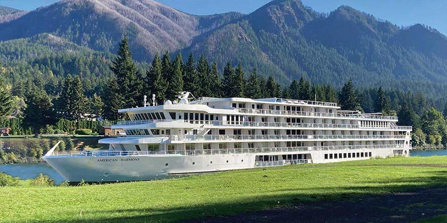 Modern riverboat moored below mountains